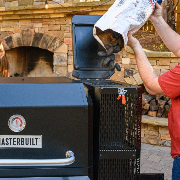 Loading charcoal into hopper by pouring it in from above