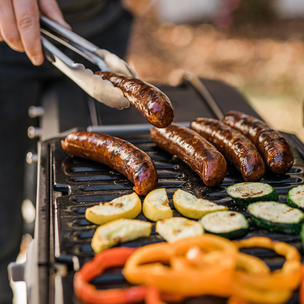 A person removes cooked food from the grill