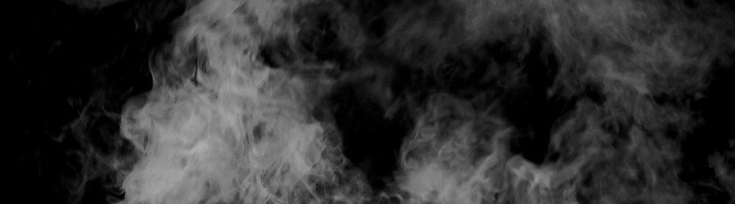 White smoke rises up against a black background