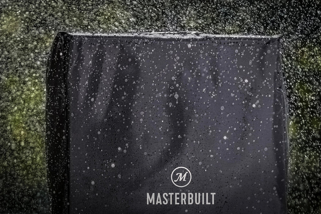 Black Masterbuilt grill cover with raindrops on a dark background
