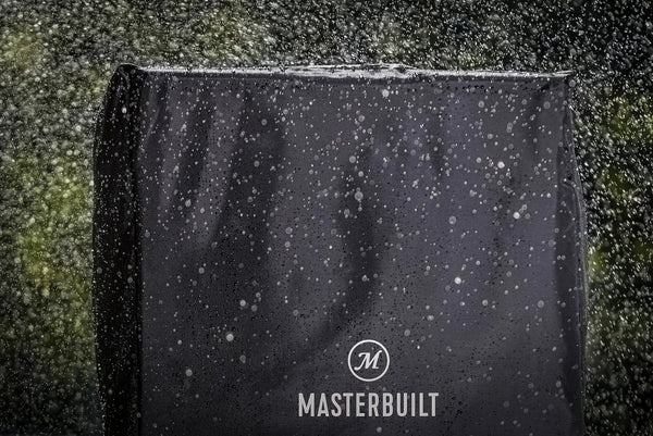 Black Masterbuilt grill cover with raindrops on a dark background