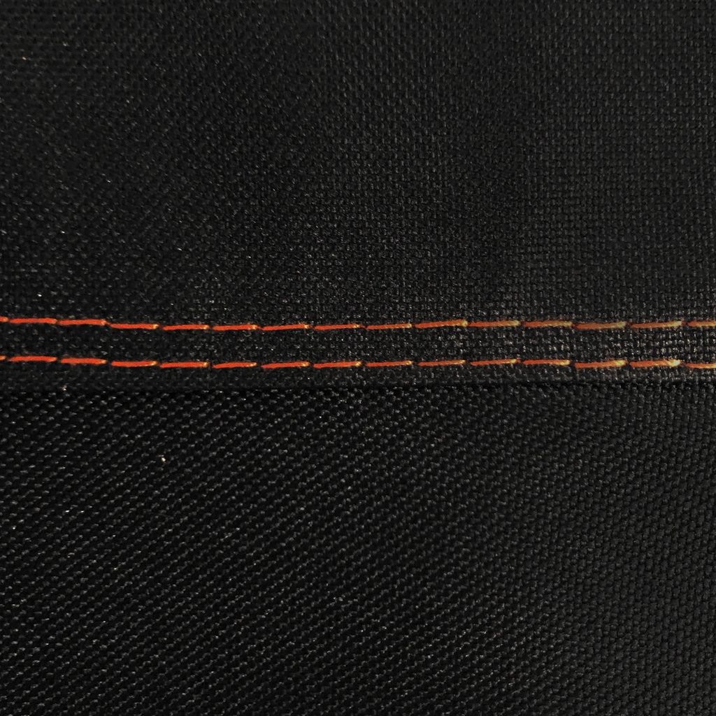 Closeup of the double-stitching on the cover. The stitching is done in orange to make a visual highlight against the black cover.