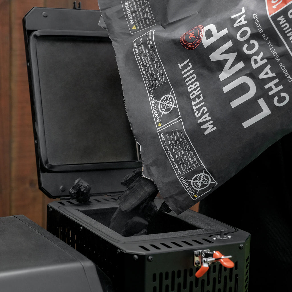 Bag of Masterbuilt lumpwood charcoal being poured into the GravityFed Charcoal Hopper of a Gravity Series BBQ